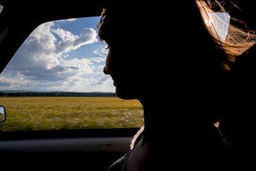 Silhouette einer lächelnden Frau als Beifahrerin im Auto - BLEF01614