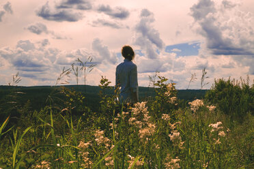 Frau in einem Feld mit Wildblumen stehend - BLEF01620