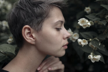 Profil einer an Blumen riechenden kaukasischen Frau - BLEF01638