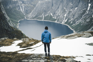 Kaukasischer Mann bewundert malerische Aussicht auf Bergsee - BLEF01674