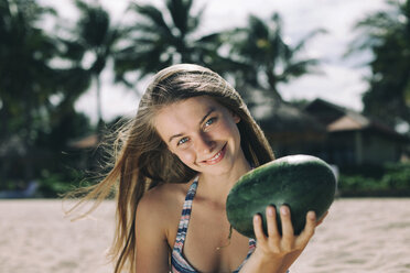 Kaukasische Frau hält Wassermelone am Strand - BLEF01683