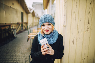 Portrait of smiling Caucasian woman holding coffee cup - BLEF01717