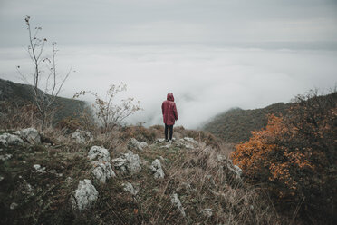 Distant Caucasian woman watching fog on ocean - BLEF01721