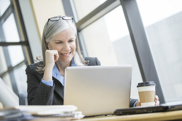 Lächelnde kaukasische Geschäftsfrau mit Laptop - BLEF01729
