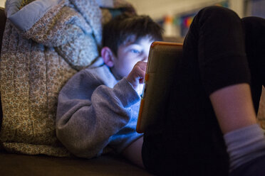 Mixed Race boy using digital tablet at night - BLEF01748