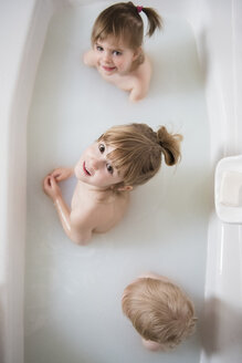 Caucasian boy and girls looking up in bathtub - BLEF01776