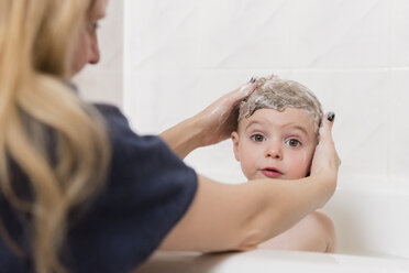 Kaukasische Mutter wäscht Haare eines Mädchens in der Badewanne - BLEF01779