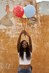 Porträt einer glücklichen jungen Frau mit drei Luftballons - VEGF00094