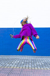 Girl listening music with headphones and smartphone jumping in the air - ERRF01221