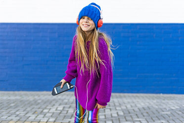 Porträt eines glücklichen Mädchens, das mit Kopfhörern und Smartphone Musik hört - ERRF01223