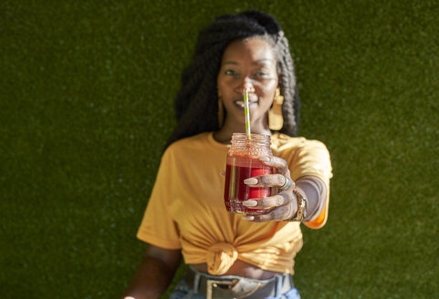 Junge Frau mit Dreadlocks hält einen Smoothie - VEGF00130