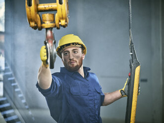 Industrial worker using hand control of indoor crane - CVF01131