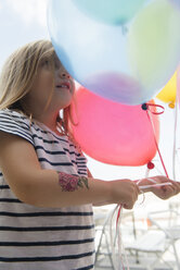 Kaukasisches Mädchen hält mehrfarbige Luftballons - BLEF01843