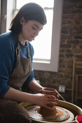 Caucasian woman shaping clay on pottery wheel - BLEF01888