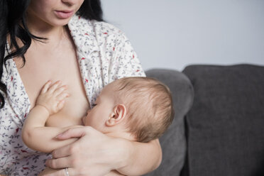 Caucasian mother breastfeeding baby son on sofa - BLEF01899