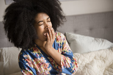 African American woman sitting in bed and yawning - BLEF01946