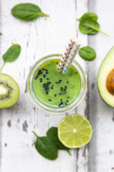 Glass of green smoothie with avocado, spinach, kiwi and lime - LVF07996