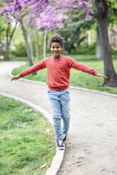 Glücklicher Junge balanciert in einem Park - JSMF01045