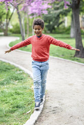 Glücklicher Junge balanciert in einem Park - JSMF01046
