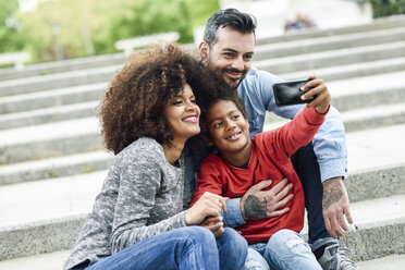 Happy family taking selfies in a park - JSMF01059