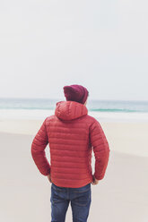 Portugal, Algarve, Sagres, Praia do Beliche, rear view of man with red cap and jacket on the beach - MMAF00881
