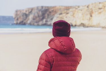 Portugal, Algarve, Sagres, Praia do Beliche, Rückansicht eines Mannes mit roter Mütze und Jacke am Strand - MMAF00882