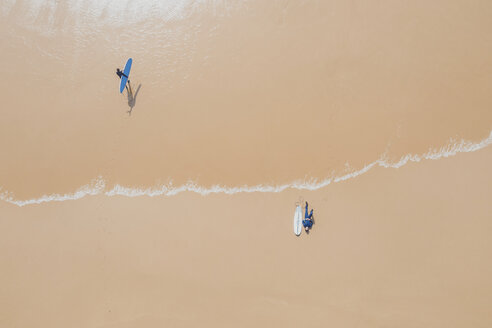 Portugal, Algarve, Sagres, Praia da Mareta, aerial view of two men with surfboards at the sea - MMAF00898