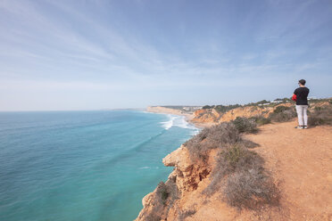 Portugal, Algarve, Lagos, Ponta da Piedade, Mann steht an der Küste und schaut auf das Meer - MMAF00913