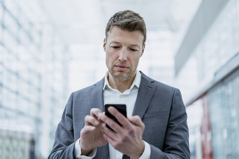 Porträt eines Geschäftsmannes, der ein Mobiltelefon benutzt, lizenzfreies Stockfoto