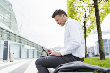 Businessman using tablet outside in the city - DIGF06847