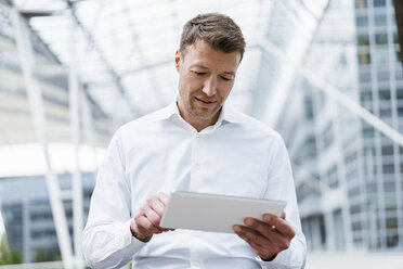 Businessman using tablet outside in the city - DIGF06851