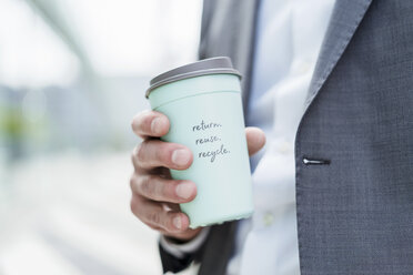 Close-up of businessman holding recycable takeaway coffee cup - DIGF06854