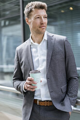 Businessman with takeaway coffee outside in the city - DIGF06855