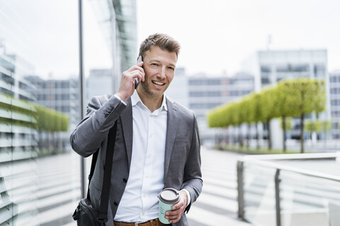 Businessman on cell phone on the move in the city stock photo