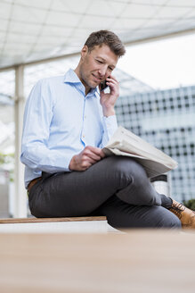 Businessman outside in the city on cell phone - DIGF06880