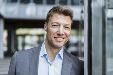 Portrait of smiling businessman outdoors - DIGF06887