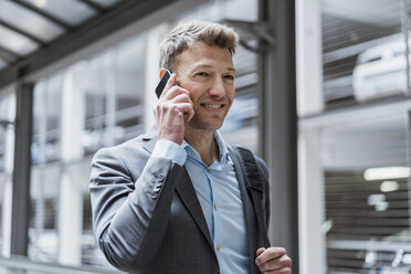 Portrait of businessman on cell phone at car park - DIGF06899