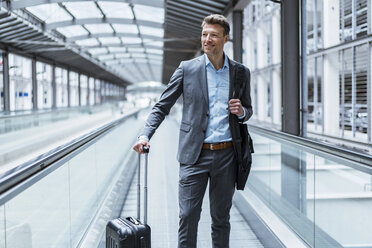 Businessman with baggage on moving walkway - DIGF06901