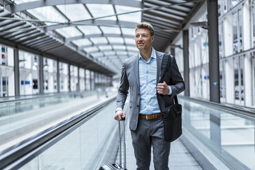 Businessman with baggage on moving walkway - DIGF06902