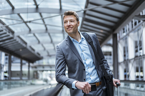 Businessman with baggage on moving walkway - DIGF06905