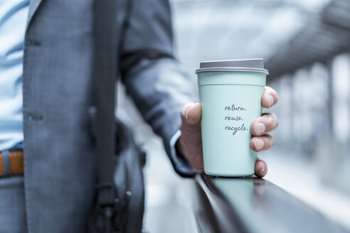Close-up of businessman holding recycable takeaway coffee cup - DIGF06910