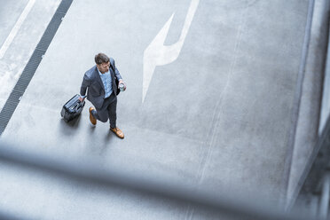 Top view of businessman walking with baggage and takeaway coffee - DIGF06913