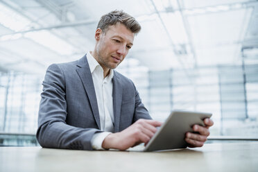 Businessman using tablet at table - DIGF06922