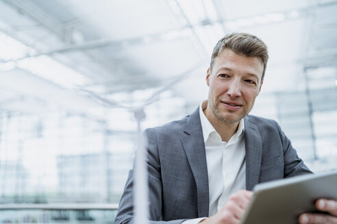 Businessman with wind turbine model and tablet - DIGF06934