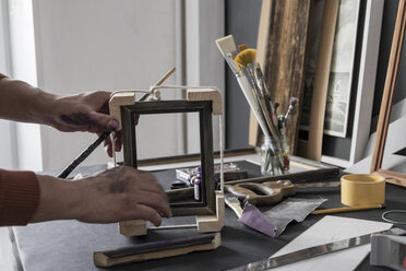 Hands of Caucasian artist making picture frame - BLEF02013