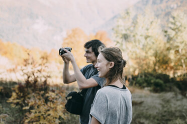 Caucasian couple photographing with camera in autumn - BLEF02031