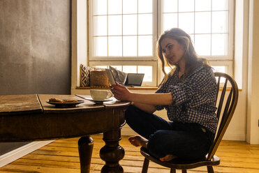 Caucasian woman reading digital tablet at table - BLEF02037