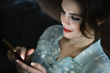 Woman texting on cell phone in the dark - BLEF02068