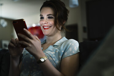 Woman texting on cell phone in the dark - BLEF02069