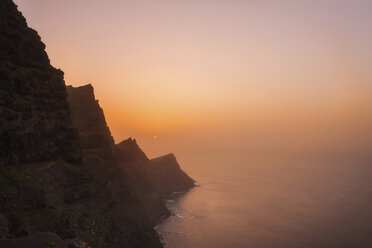 Spain, Gran Canaria, rocky cliff at sunset - DHCF00194